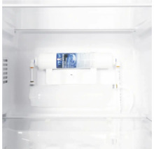 Ein weißer Kühlschrank-Wasserfilter, der im Inneren eines Kühlschranks installiert und mit Wasserleitungen verbunden ist.