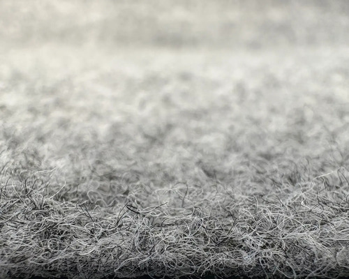 Gros plan de la structure de surface d'une moquette en feutre aiguilleté.