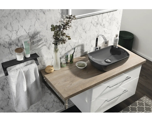 Modernes Badezimmer mit grauem Aufsatzwaschbecken auf Holzplatte, weißem Unterschrank und Wandfliesen in Marmoroptik.