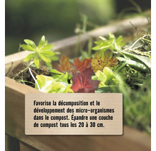 Compost dans un bac en bois avec feuilles et instructions pour favoriser la décomposition et les micro-organismes tous les 20 à 30 centimètres.