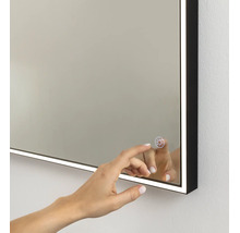 Miroir de salle de bains éclairé avec cadre noir et capteur tactile pour commander l'éclairage LED.