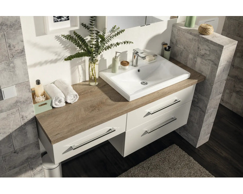 Meuble de salle de bain moderne avec vasque en céramique blanche sur un plan de toilette aspect chêne. Meuble bas avec trois tiroirs.