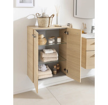 Armoire de salle de bain murale en aspect bois clair avec deux portes, trois étagères en verre et des articles de toilette bien rangés.