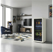 Moderner, heller Raum mit einem hohen cremefarbenen Getränkekühlschrank mit Glastür, einem blauen Sessel, Arcade-Automaten und Fernseher.