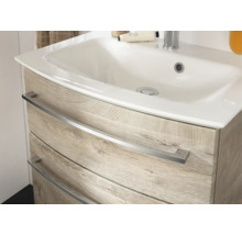 Meuble sous-vasque avec lavabo en céramique et deux tiroirs aspect chêne avec poignées en métal.