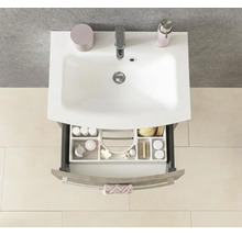 Meuble sous-lavabo aspect bois avec vasque blanche et tiroir ouvert avec aménagement, vue de dessus.