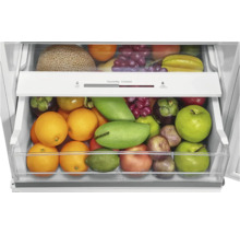 Kühlschublade mit Feuchtigkeitsregler, gefüllt mit verschiedenen Obstsorten wie Orangen, Äpfeln und Mangos.