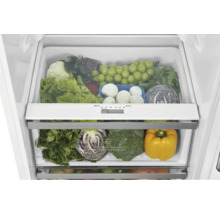 Kühlschrank-Innenansicht mit zwei Gemüsefächern voller frischem Obst und Gemüse sowie einem Feuchtigkeitsregler.