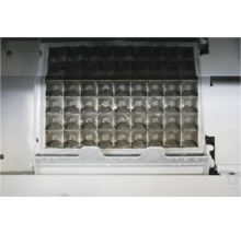 Innenansicht eines Eiswürfelbereiters mit einem Gitter aus Metall zur Herstellung von Eiswürfeln.