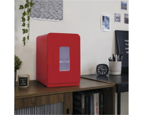 Roter Mini-Kühlschrank mit Sichtfenster auf einem Holzschrank in einem hellen, organisierten Raum mit Bürozubehör.