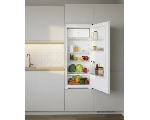 Moderner Einbaukühlschrank mit geöffneter Tür, integriert in helle Küchenschränke mit Holz-Arbeitsplatte und weißem Fliesenspiegel.
