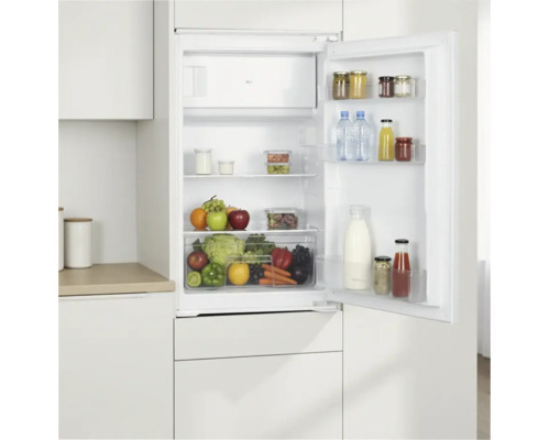 Offener Einbaukühlschrank befüllt mit frischen Lebensmitteln und Getränken, eingebaut in einen Küchenschrank.