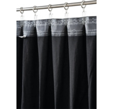 Rideau en tissu foncé sur une tringle à rideaux en métal avec anneaux et clips métalliques.
