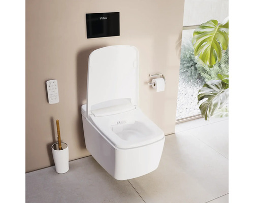 Toilette douche suspendue blanche avec télécommande et plaque de commande noire avec VitrA Logo dans une salle de bains lumineuse et organisée.