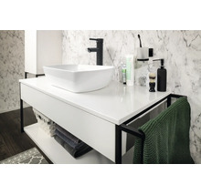 Salle de bains moderne et lumineuse avec vasque à poser blanche sur meuble avec cadre noir, robinetterie noire et mur aspect marbre.