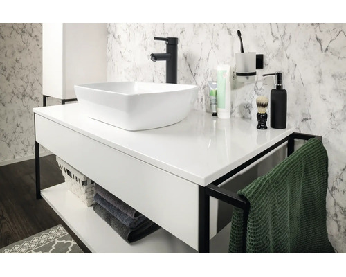 Salle de bains moderne et lumineuse avec vasque à poser blanche sur meuble avec cadre noir, robinetterie noire et mur aspect marbre.