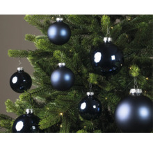 Blaue Weihnachtskugeln in verschiedenen Größen, teils matt und teils glänzend, an einem grünen Weihnachtsbaum.