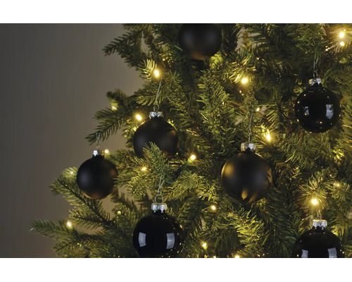 Weihnachtsbaum mit warmweißer Beleuchtung und schwarzen Christbaumkugeln in matter und glänzender Ausführung.