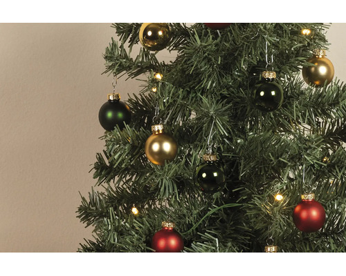 Künstlicher Weihnachtsbaum mit roten, grünen und goldenen Weihnachtskugeln in glänzend und matt sowie warmweißen LED-Lichtern.