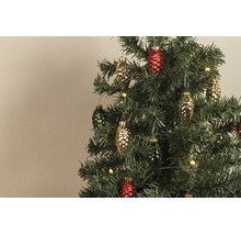 Farbige Glasanhänger in Zapfenform an einem künstlichen Weihnachtsbaum mit warmweißen Lichtern.
