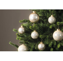 Weihnachtskugeln mit glitzerndem Schneeflocken-Muster an den Zweigen eines Tannenbaums.