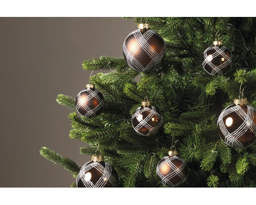 Braune Weihnachtskugeln mit silbernem Gittermuster an einem grünen Tannenbaum.