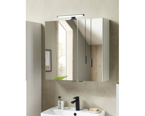 Armoire de toilette moderne à deux portes avec éclairage LED au-dessus d'un lavabo blanc avec un robinet noir dans une salle de bains.