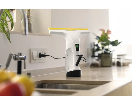 Nettoyeur de vitres sans fil Kärcher en charge sur une prise de courant sur un plan de travail de cuisine.
