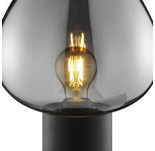 Lampe à poser avec globe en verre rond et ampoule à filament apparente sur un pied simple.