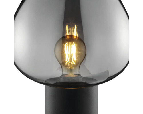 Lampe à poser avec globe en verre rond et ampoule à filament apparente sur un pied simple.