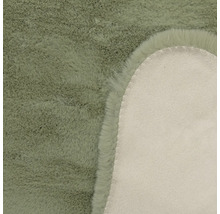 Vue détaillée d'un tapis en fausse fourrure avec des poils doux et l'envers en textile.
