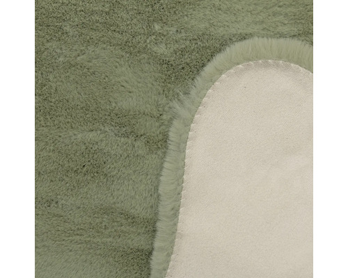 Vue détaillée d'un tapis en fausse fourrure avec des poils doux et l'envers en textile.