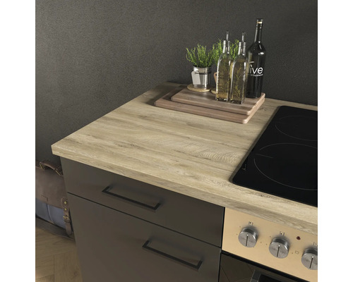 Plan de travail de cuisine moderne en aspect chêne clair sur un meuble bas sombre à côté d'une plaque de cuisson, avec planches à découper.