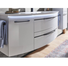 Meuble sous-vasque suspendu moderne avec façade incurvée, poignées noires et éclairage LED intégré sous le plan de toilette.