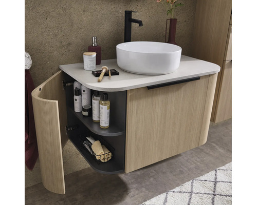 Wandhängender Waschtischunterschrank mit geriffelter Holzfront, weissem Aufsatzwaschbecken und schwarzer Armatur in einem modernen Badezimmer.