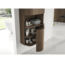 Moderner Badezimmer-Hängeschrank mit vertikalen Holzrillen und abgerundeter Tür, organisiert mit Handtüchern und Pflegeprodukten.