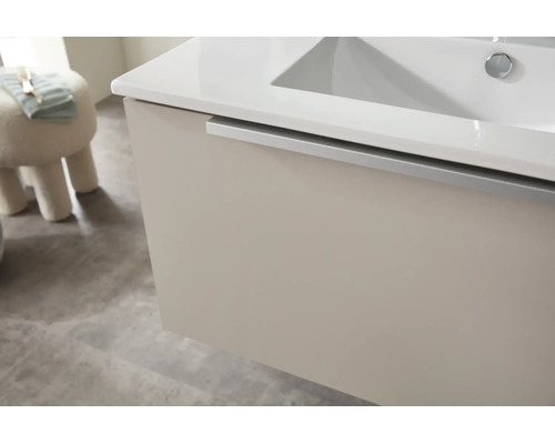 Waschtischunterschrank mit weissem Waschbecken und silberner Griffleiste in einem modernen Badezimmer.