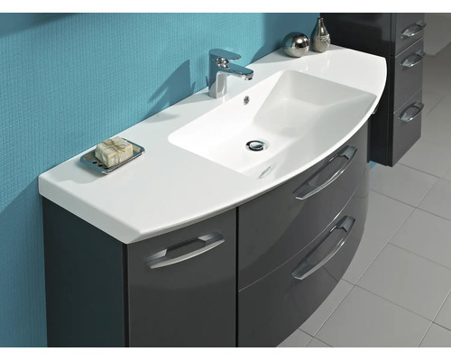 Meuble de salle de bain avec vasque blanche, mitigeur chromé et meuble bas gris foncé brillant avec façade incurvée.