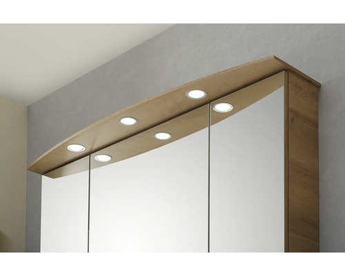 Armoire de toilette trois portes aspect bois avec six spots LED intégrés dans la corniche.