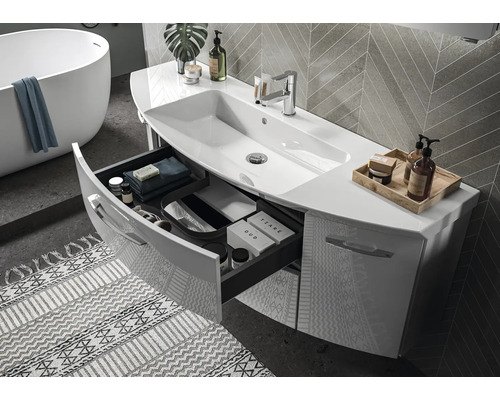 Salle de bains moderne avec meuble sous-vasque blanc, tiroir ouvert, lavabo intégré et baignoire îlot.