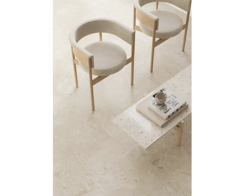 Helle Bodenfliesen in Steinoptik in einem minimalistisch eingerichteten Raum mit zwei Stühlen und einem Couchtisch.