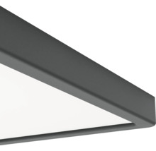 Vue détaillée d'un angle de panneau LED avec cadre métallique anthracite et surface lumineuse blanche.
