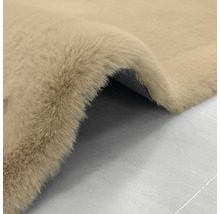 Beigefarbener, weicher Kunstfellteppich mit Hochflor und strukturierter Rückseite.