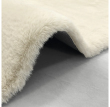 Hochflor-Kunstfell-Teppich in Creme, weiche Textur mit sichtbarer dunkler Rückseite.