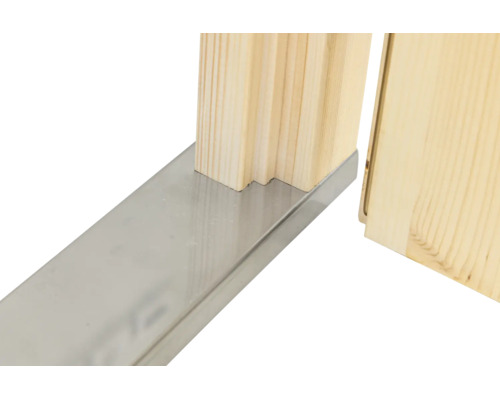 Detailansicht einer Türzarge aus Holz mit einer Bodenschwelle aus Metall.