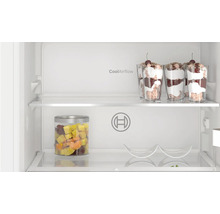 Vue intérieure d'un réfrigérateur Bosch avec étagères en verre, logo Bosch, système CoolAirflow et aliments dans des verres.