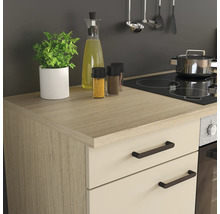 Cuisine moderne avec plan de travail effet bois, façades claires, plaque de cuisson intégrée, four et ustensiles de cuisine bien rangés.