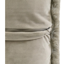 Gros plan du dos d'une housse de coussin avec fermeture éclair invisible et bordure en fausse fourrure douce.