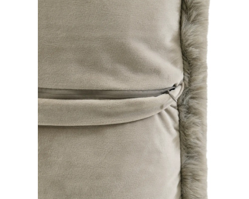 Gros plan du dos d'une housse de coussin avec fermeture éclair invisible et bordure en fausse fourrure douce.