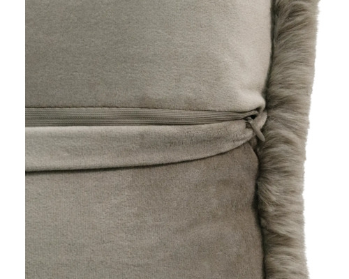 Gros plan de l'arrière du coussin en velours avec fermeture éclair dissimulée et bord en fausse fourrure.